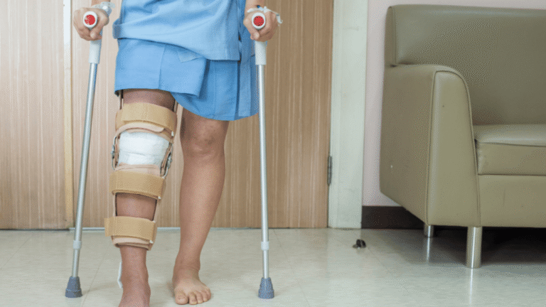 Pasient som går på krykker etter operasjon med kneprotese