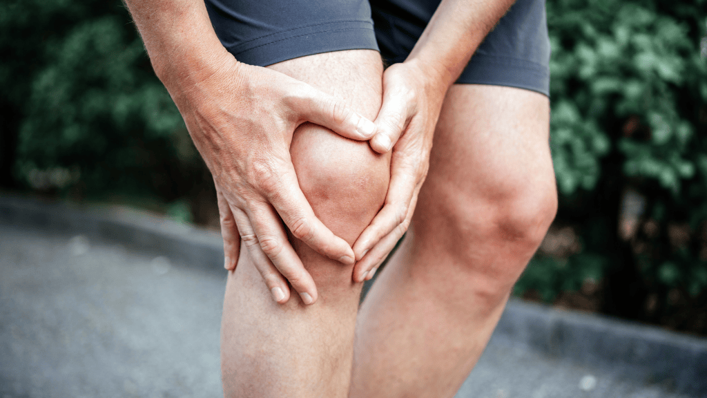 Person holding a painful knee, a common symptom of a meniscus tear