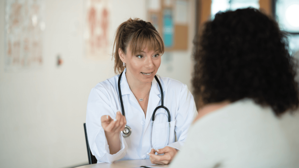 Médico explicando al paciente las opciones de tratamiento de las hemorroides durante la consulta