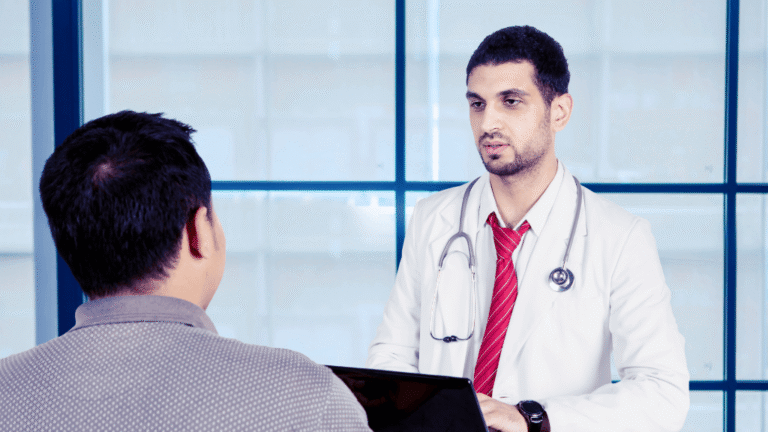 Médico hablando del procedimiento de vasectomía con un paciente varón durante la consulta