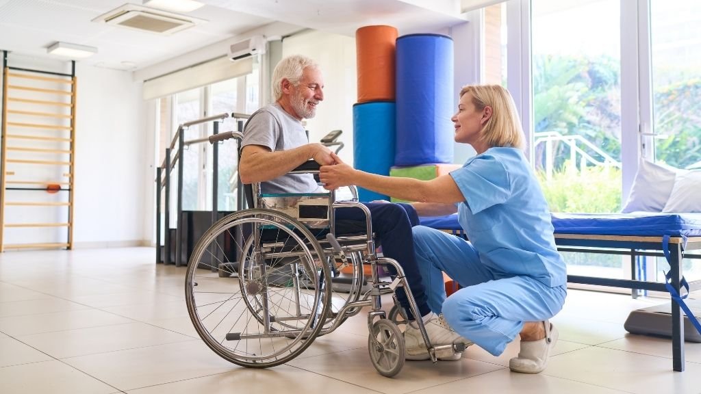 Paciente en silla de ruedas durante una sesión de rehabilitación ortopédica en un hospital de España.