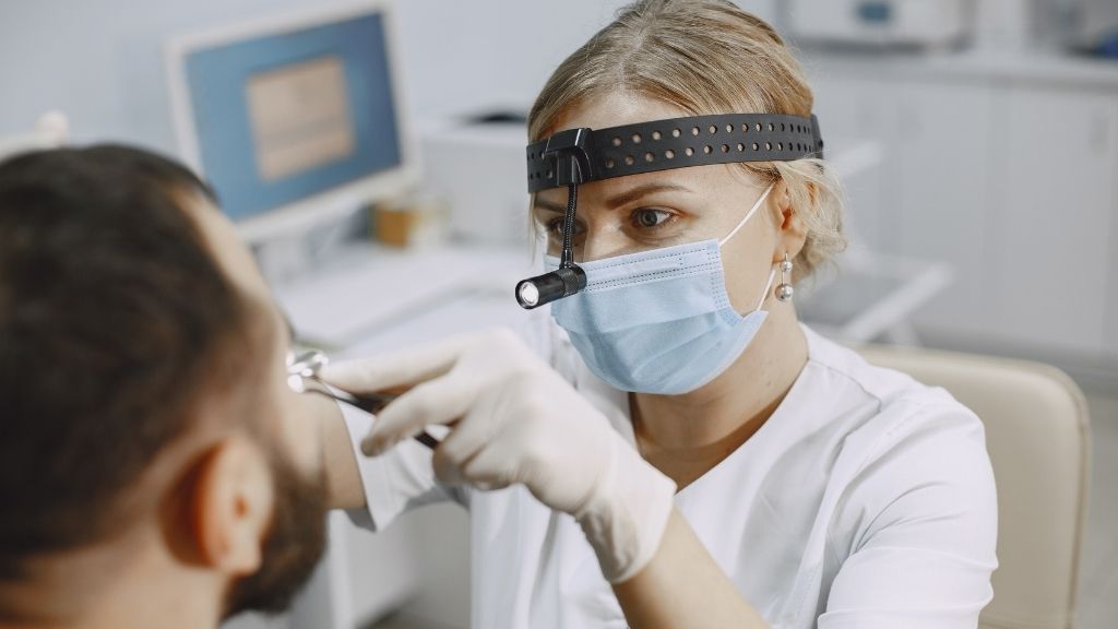 Un ORL examine un patient avant une opération des sinus en Espagne